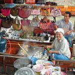 A native of the floating market making coconut pancakes for sale from her boat.