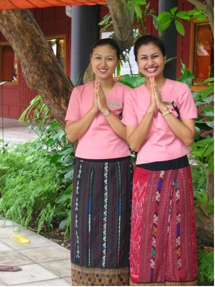 Smiling Thai guide welcome visitors to the Jim Thompson home in Bangkok