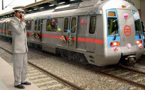 A uniformed platform attendant speaks on his walkie-talkie as a decorated train carrying guests and VIPs prepares to leave the Seelampur station of the Delhi Metro.
