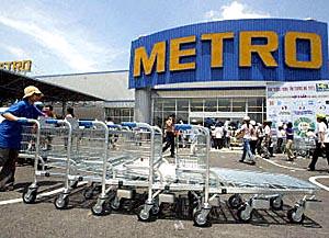 An employee pushes handcarts in front of the first Metro Cash and Carry wholesale center in Hanoi. Germany's Metro Group plans to open eight wholesale centers in Vietnam.