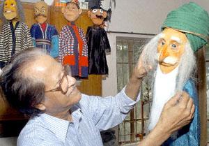 Bangladeshi artist Mostafa Monawar, known as the 'puppet man' puts the final touches to a puppet in Dhaka.