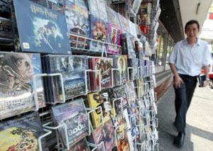 A Thai man walks past a VCD movie stall at a market in Bangkok.