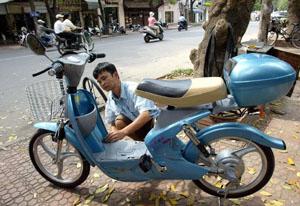 A mecanic puts the last finishing touch on a Chinese-made electric motorbike before its delivery in front of a bicycle shop in downtown Hanoi.