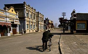 A man pushes his bicycle through a deserted film set at the Korean Feature Film Studio just outside the North Korean capital of Pyongyang.