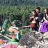 Two Kashmiri brothers and their twin sisters sit on a rock looking at rides inside Kashmir's first amusement park in Pahalgam.