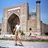 A tourist poses in front of Ragestan palace, in the ancient Uzbek city of Samarkand. This large city of Islamic art was founded in V century B.C.