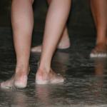Khanh's girlfriend's long Swiss legs and feet, dancing in the rain and chalk after his performance.