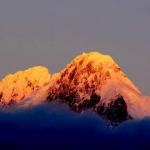 The towering Meili Snow Mountain is gilt by the rising sun, shining in the sky of Shangri-la.