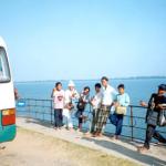 The children wait patiently for a group of tourists to disembark from their van.