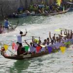 The Esso dragon boat crew lift their paddles in the air as they cross the finish line in the dragon boat races on Lamma Island, Hong Kong, 16 April 2001. The dragon boat races are an annual event and this year was won by a local crew under the banner of Esso.