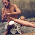 A trained masseurs giving an oil massage at a "ghat" (platform constructed on the river bank) in Varanasi. These masseurs ply their trade at "ghats" in religious places, where people throng to worship in the river, a custom that has been prevalent for centuries. These masseurs, it is believed, can cure all kinds of aches, pains and minor ailments.