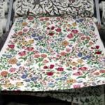 Indian Kashmiri salesmen unroll fabric adorned with traditional Kashmiri embroidery to show to a customer at a shop in Srinagar.