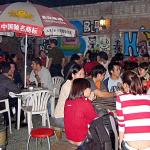 Foreign students gather at the Bla Bar at Beijing's Foreign Languages University on a typical Friday night 24 September 2004. With more than 30,000 foreign students living and studying in Beijing, a part of the capital's Haidian university district has turned into a cosmopolitan party center where students from around the world gather against a distinctly Chinese backdrop.