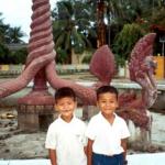 Two boys pose in front of the downtown Kratie fountain.