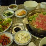 A meal of beef slices with dumplings boiled in a delicious broth cost KRW12,000 per person. Other side dishes include kimchi, preserved cabbage, potato salad, soup and more.