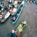 Boats loaded with fruits and vegetables move towards the river bank at Phung Hiep in Can Tho Province. Farmers and traders come from all over the Mekong to trade and sell their goods at this market town where seven canals converge.