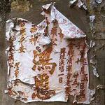 Tattered poster peels off a wall in Chinatown.