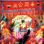 An inner shrine may contain a few figures of ancient Chinese men (ancestor worship), a garuda figurine (Hinduism), a yin-yang (dualism), and an amulet containing a miniature monk statue (Buddhism). It may also contain a host of other objects whose religious significance is unclear or nil (joss sticks, garlanded elephant statues, tiger paintings, peacock feathers, potted plants.) The result often resembles a stall at a flea market, or a garish and dusty curio store in some Chinatown.